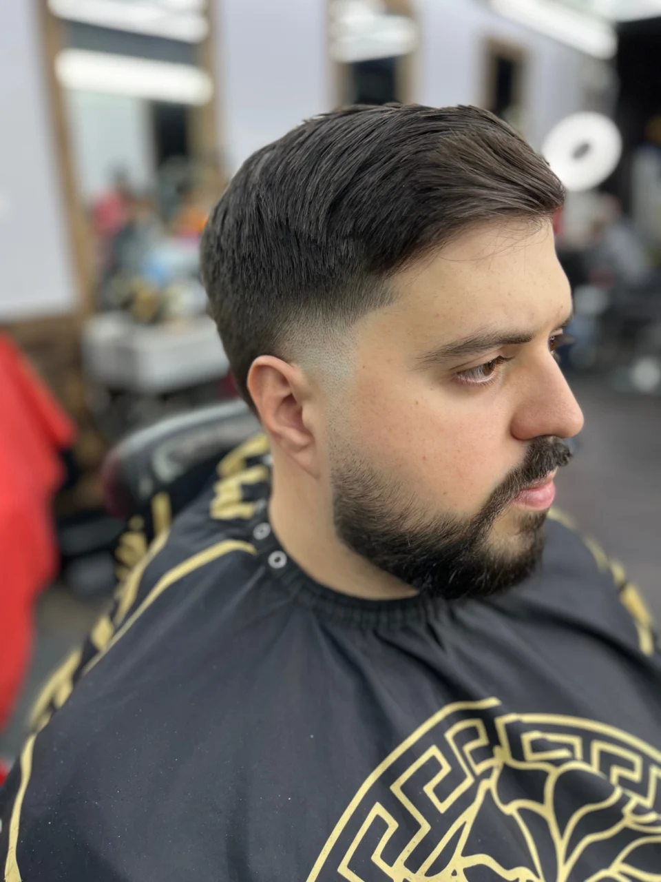 Side-part haircut with a blended fade and trimmed beard